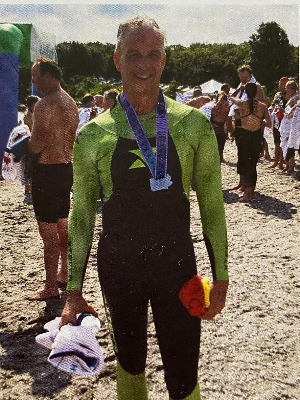 Keith Ryan poses for a portrait at the finish of the 2019 Save the Bay swim. Keith died on June 3, 2023. On his prayer card, shown above, he promised us: "I will always be with you. If you go for a swim, I am stroking right beside you."